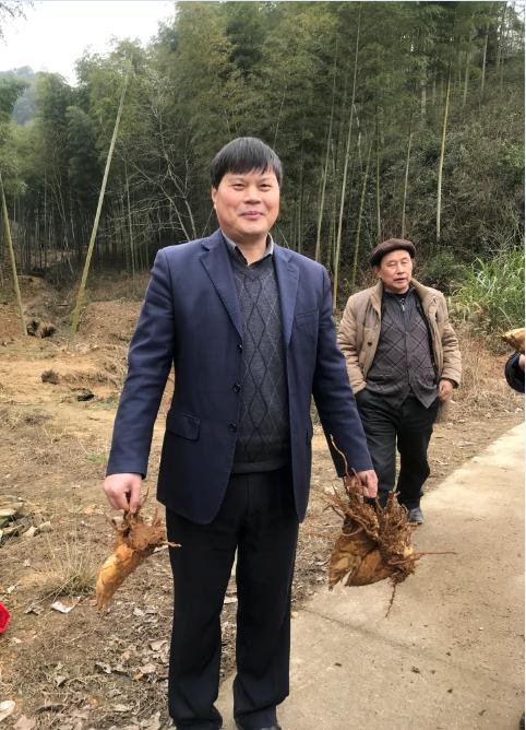 项目合作单位县林业技术推广站站长杨军手提冬笋,喜笑颜开